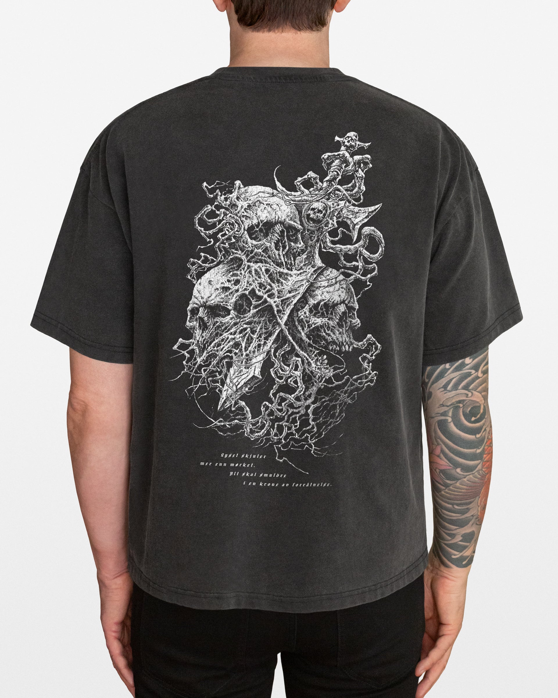 Person wearing a dark gray acid washed t-shirt with a Skulls and Sword graphic on the back against a plain background
