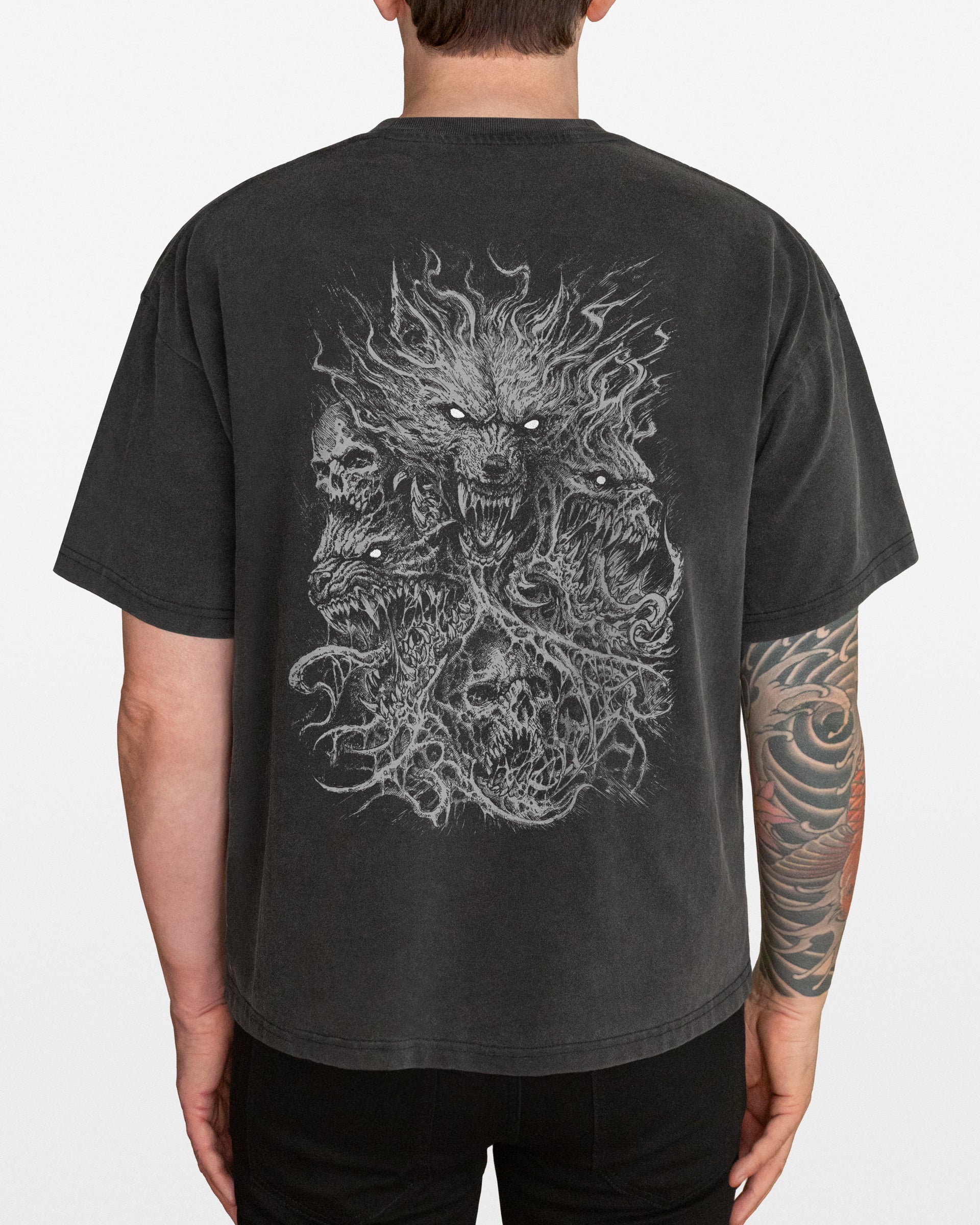 A dark gray acid wash oversized t-shirt with a Wolves design on the back, worn by a person.