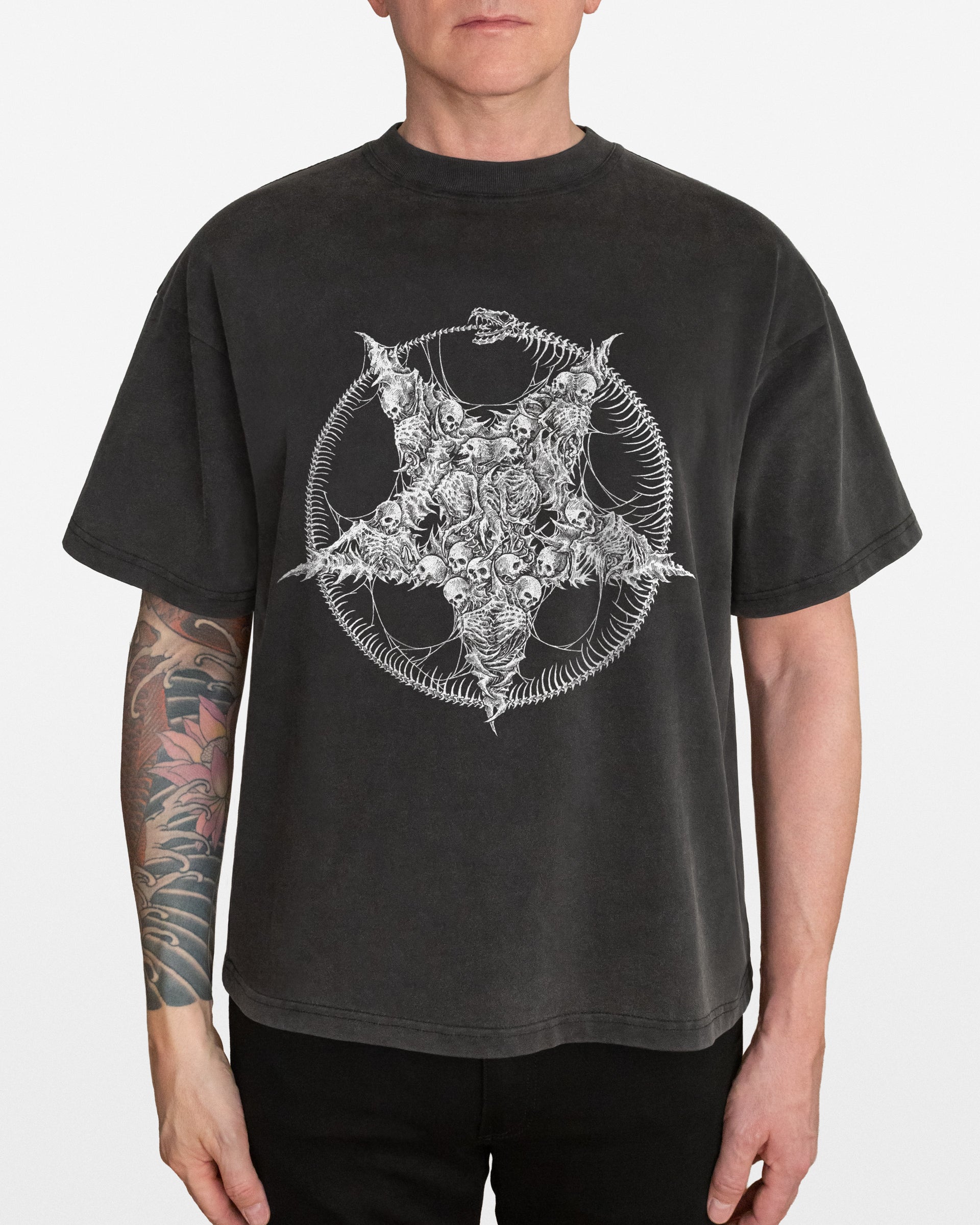 Person wearing a black t-shirt with a white pentagram design on a plain background