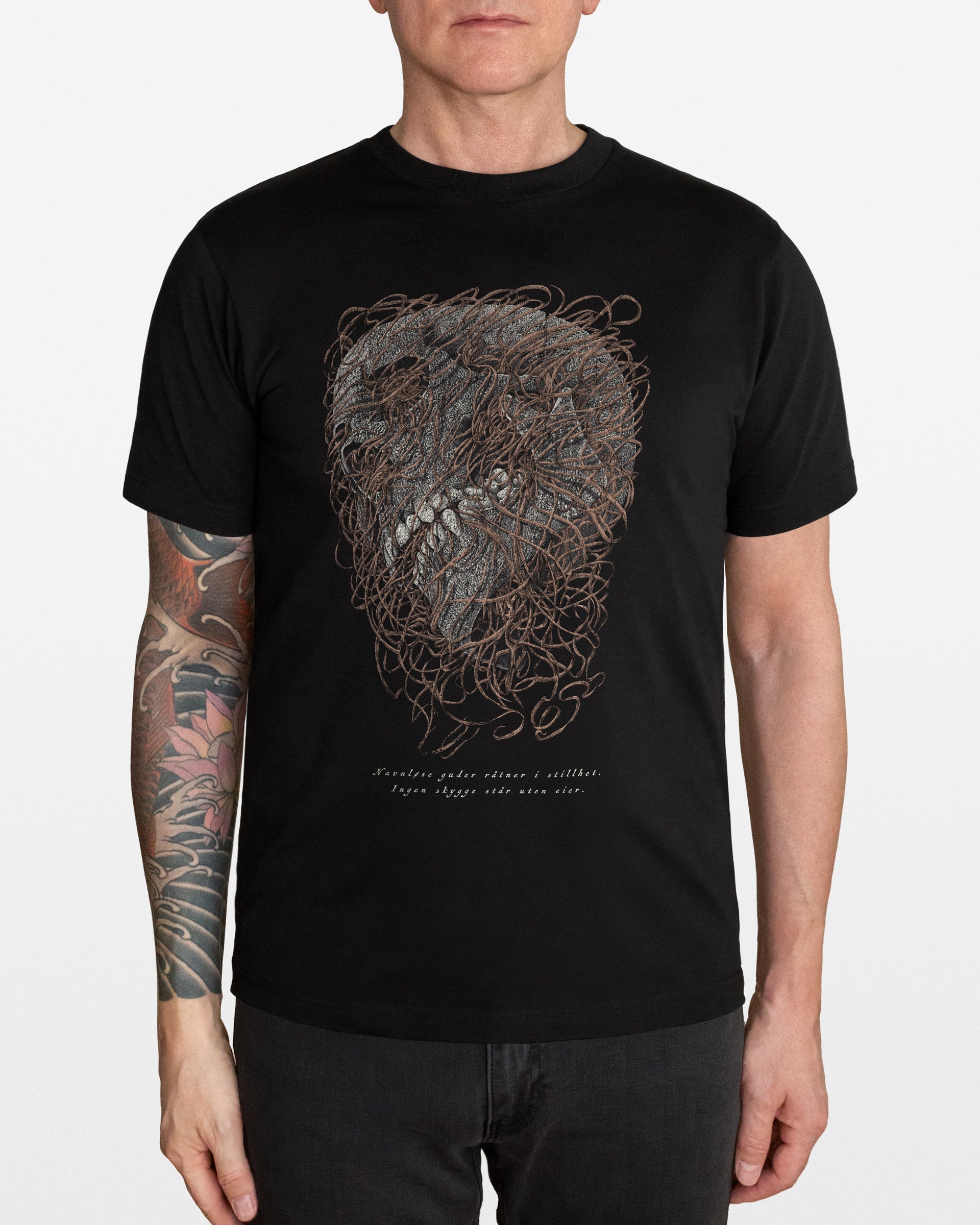 Person wearing a black t-shirt with a detailed skull design, on a white background