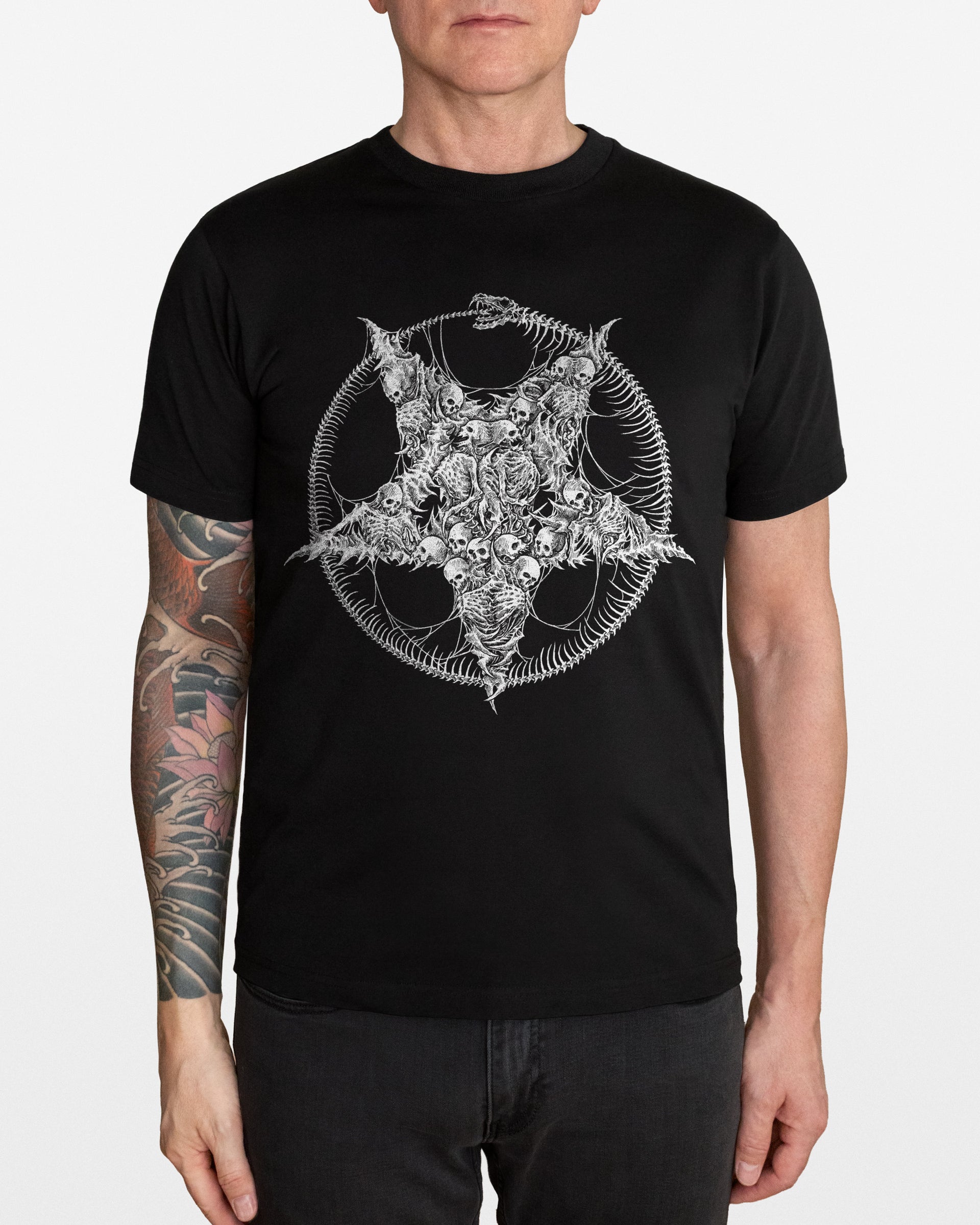 Person wearing a black t-shirt with a white pentagram and skeletons design on a plain background