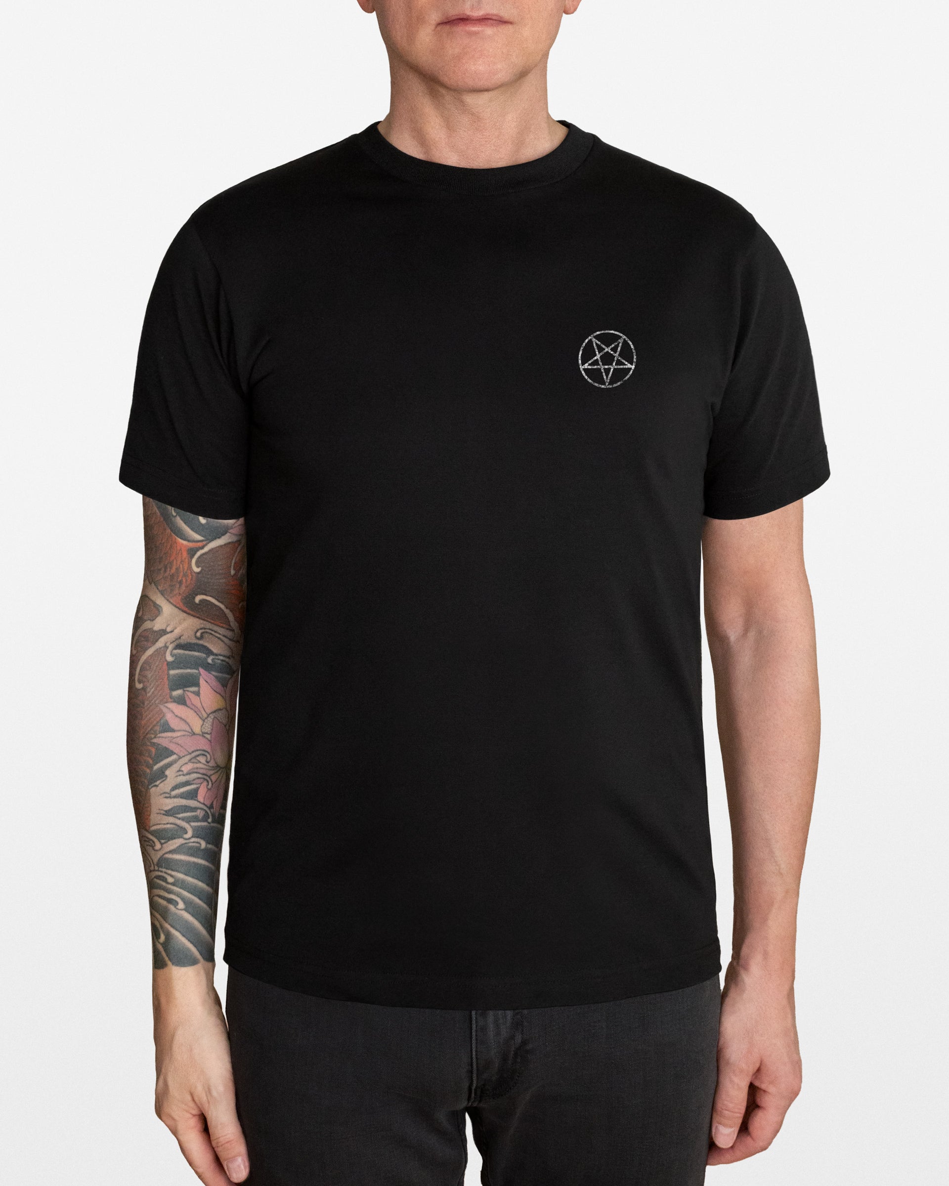 Person wearing a black t-shirt with a small white Pentagram on a white background