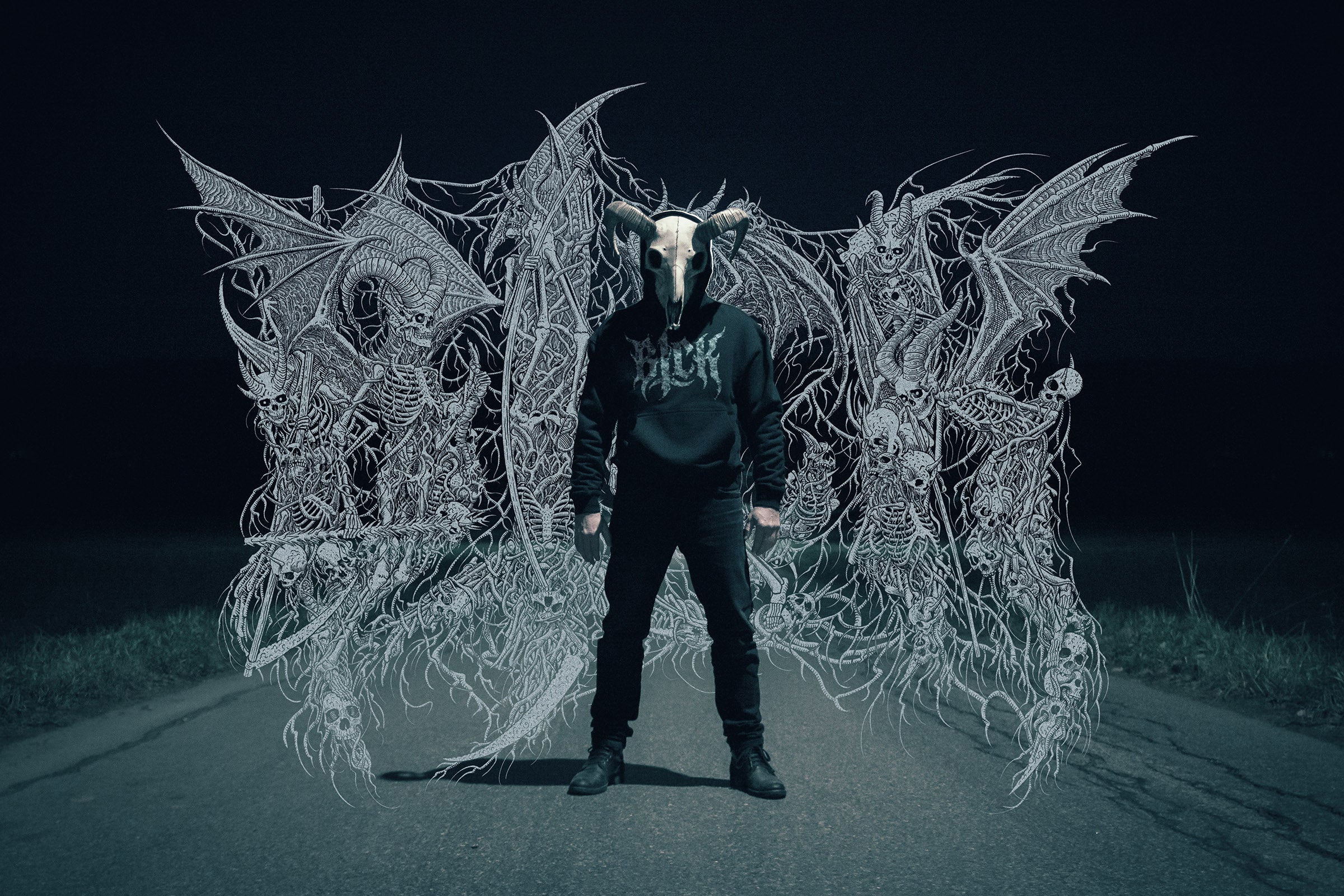 Person wearing a goat skull mask and a dark hoodie with a logo, standing in front of intricate demonic skeletons artwork.