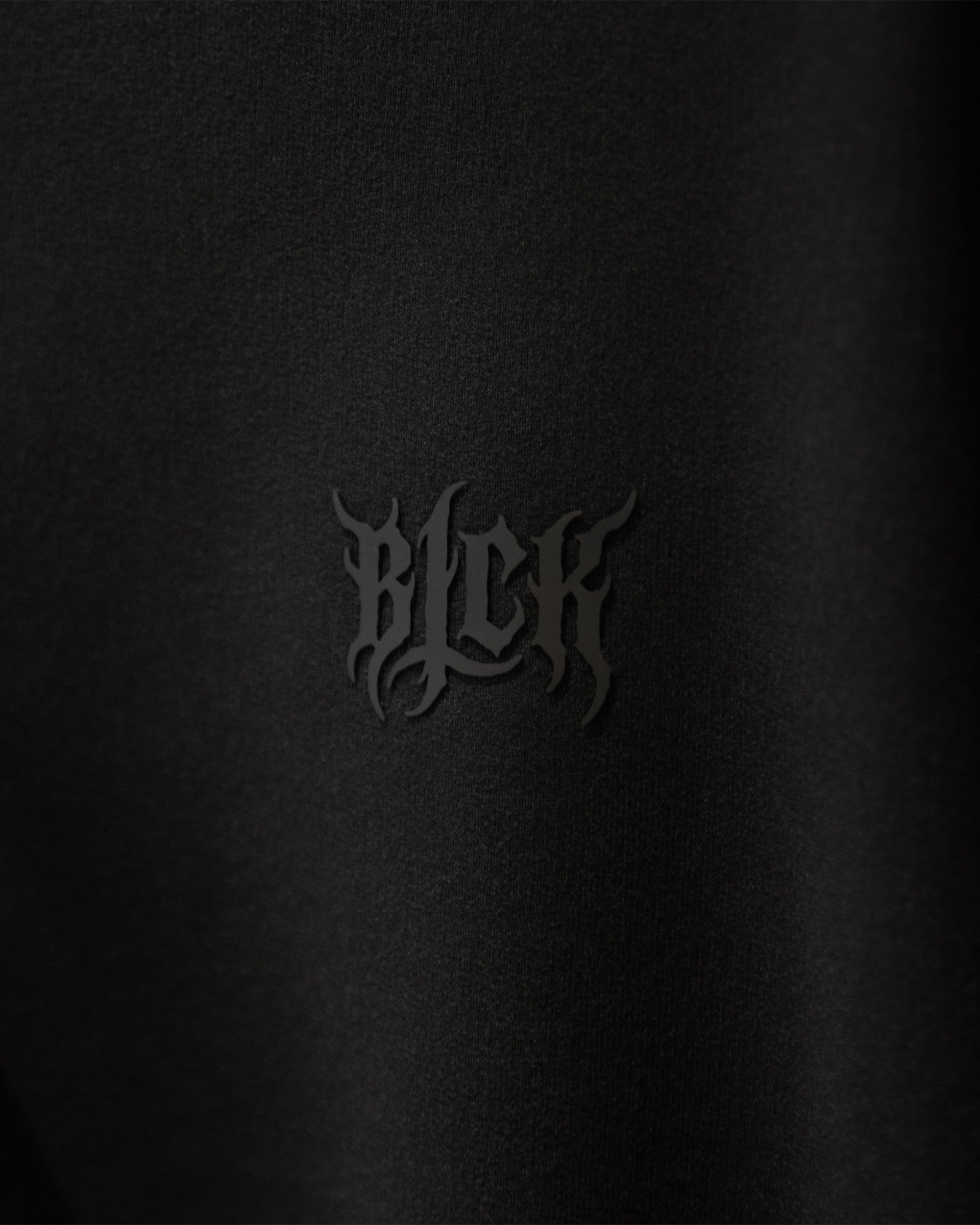 Small silicone logo on black hoodie front chest