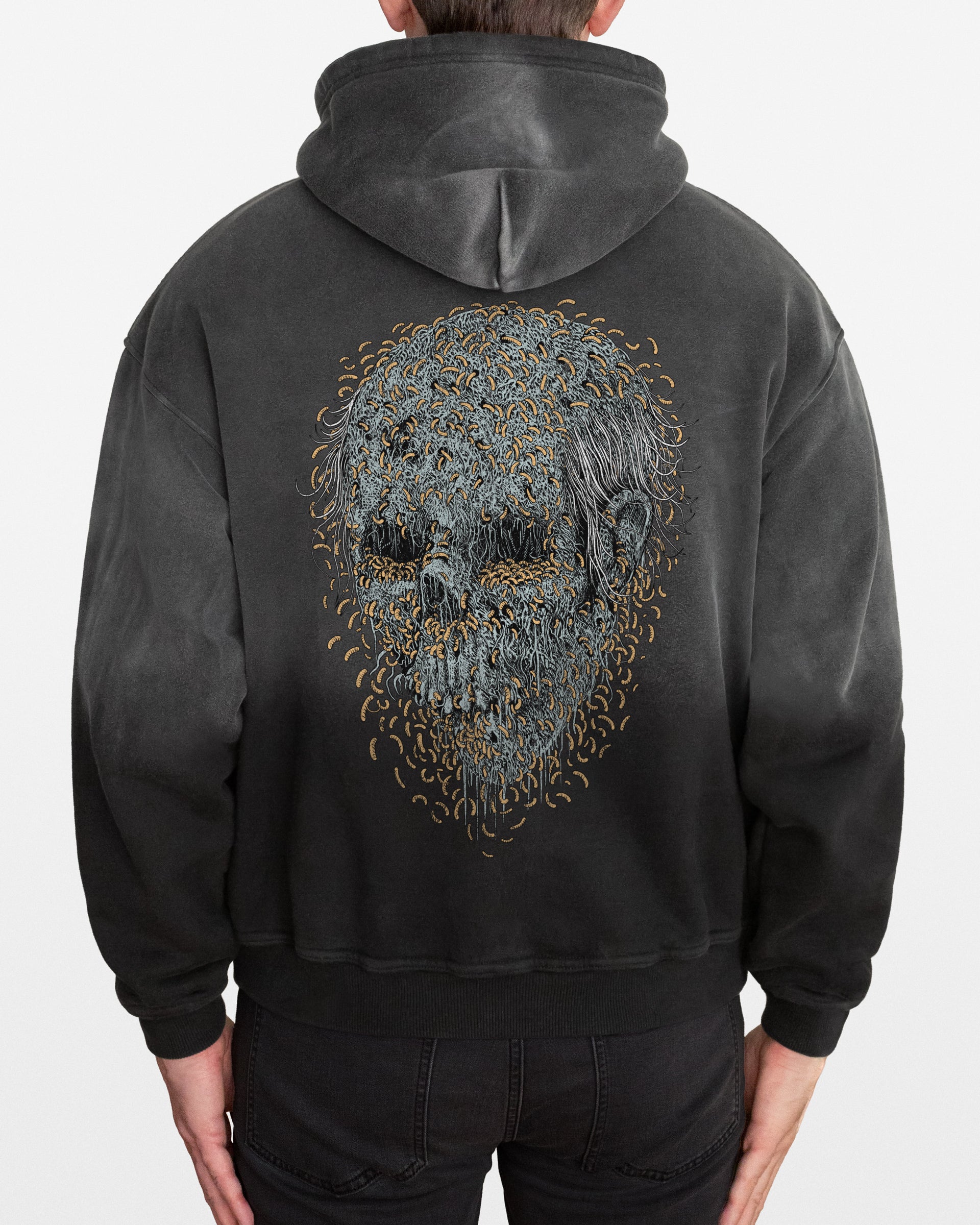 Dark gray sun faded hoodie with a detailed maggot skull design on the back, worn by a person.