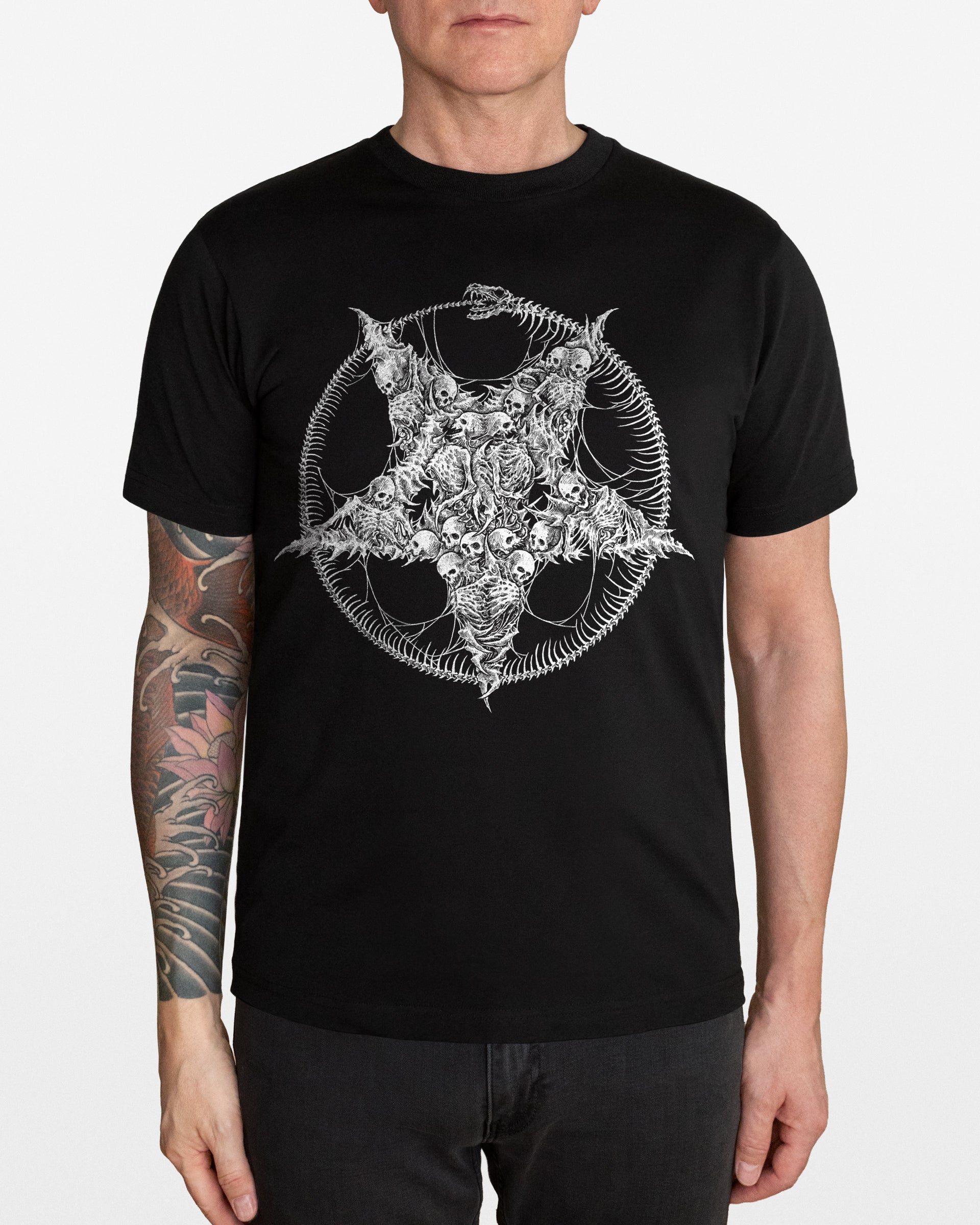 Person wearing a black t-shirt with a white pentagram and skeletons design on a plain background