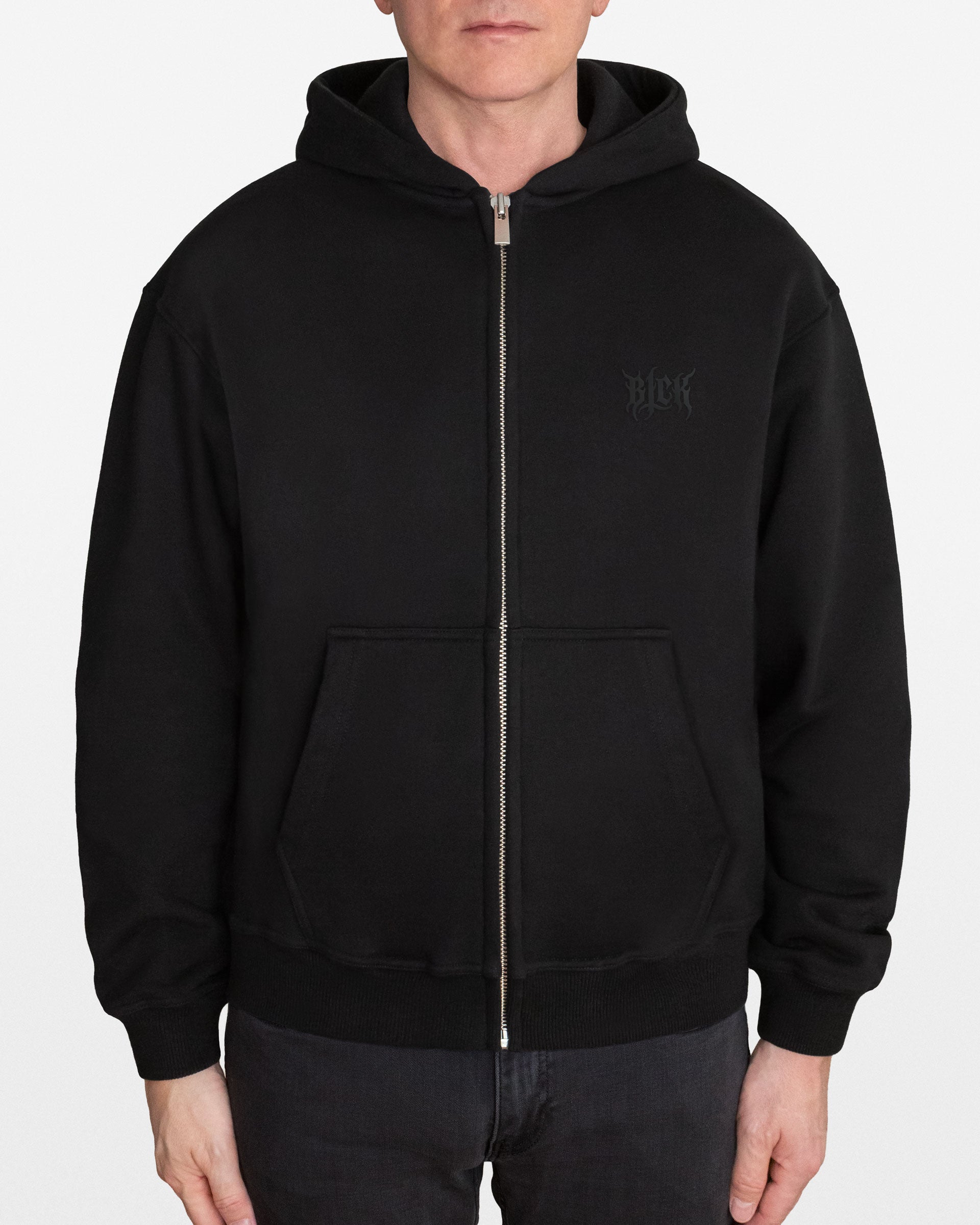 Person wearing a black zip hoodie with a BLCK logo, on a white background
